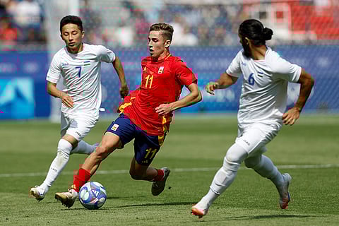 Fermin Lopez competes for the ball with Uzbekistan players
